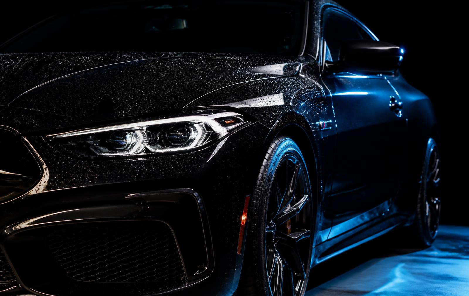 Freshly detailed black car with water beading on glossy paintwork
